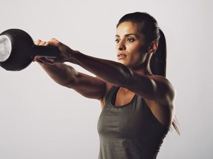 Ein Mädchen führt mit einer Kettlebell eine Übung durch, um ihre Brüste zu vergrößern
